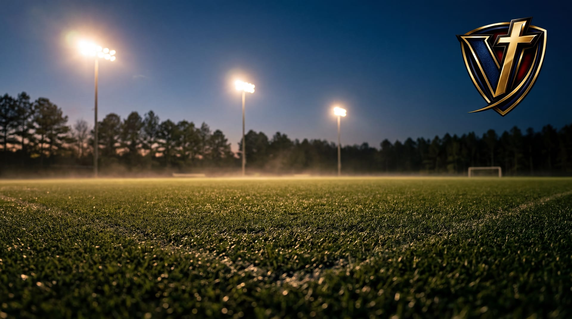 Stadium lights on over an empty tournament turf field at twilight